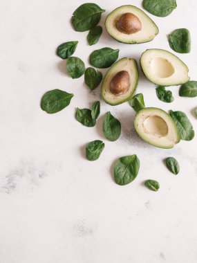 Yukarıdan kesilerek avokado Fesleğenli yeşil beyaz beton zemin üzerine bırakır