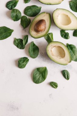 Yukarıdan kesilerek avokado Fesleğenli yeşil beyaz beton zemin üzerine bırakır