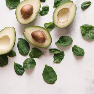 Yukarıdan kesilerek avokado Fesleğenli yeşil beyaz beton zemin üzerine bırakır