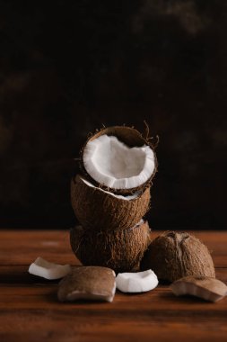 Koyu ahşap arka plan üzerinde kırık hindistancevizi yığını