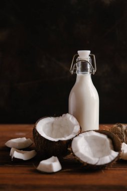 Hindistan cevizi sütü koyu ahşap arka plan üzerinde kırık hindistancevizi ile