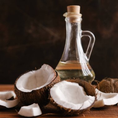 Hindistancevizi yağı şişe ile ahşap arka plan üzerinde kırık