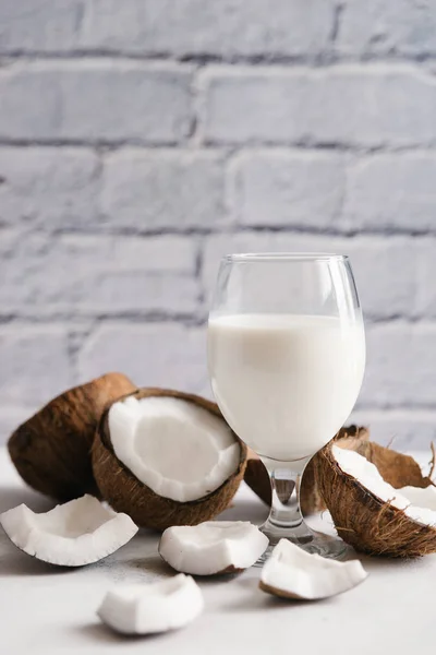 Hindistan cevizi sütü beyaz masa üzerinde kırık cevizli