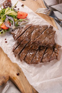 Yeşil salata ve bir bardak kırmızı şarap ile kıyılmış sığır eti biftek servis