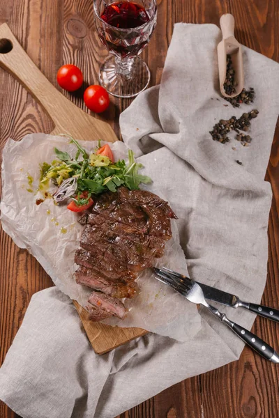 stock image Chopped beef steak served with green salad and glass of red wine