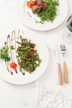 Kurutulmuş domates ve beyaz tabakta sos ile servis kavrulmuş yeşil fasulye