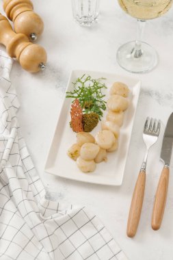 Yeni haşlanmış patates sosu ve beyaz plaka üzerinde taze roka ile servis