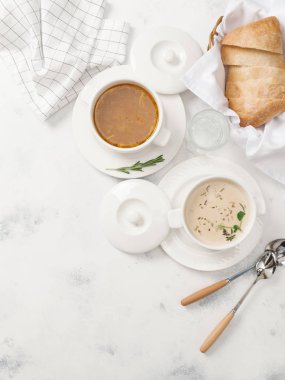 Beyaz arka plan üzerinde otlar ile iki tür krem çorba servis