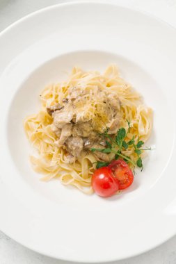 Beyaz tabakta et sos ve parmesan peynirli makarna