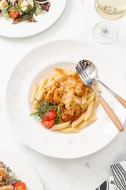 Beyaz tabak içinde sığır eti ve parmesan peynirli taze makarna üstten görünüm