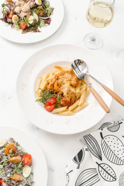 Beyaz tabak içinde sığır eti ve parmesan peynirli taze makarna üstten görünüm