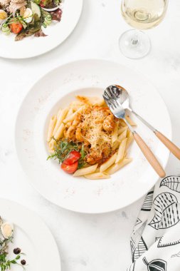 Beyaz tabak içinde sığır eti ve parmesan peynirli taze makarna üstten görünüm