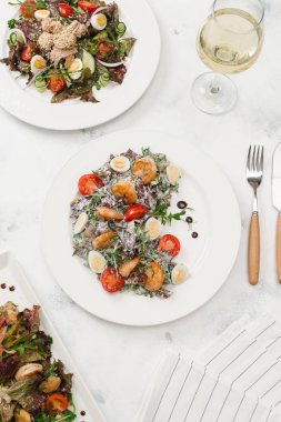 Yeşil salata domates, bıldırcın yumurtası ve beyaz plaka üzerinde Kızarmış karides ile