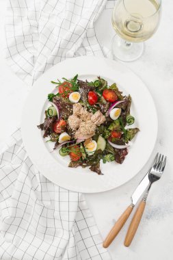 Yeşil Salata tavuk, domates, bıldırcın yumurtası ve beyaz tabakta salatalık ile