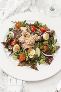 Yeşil Salata tavuk, domates, bıldırcın yumurtası ve beyaz tabakta salatalık ile