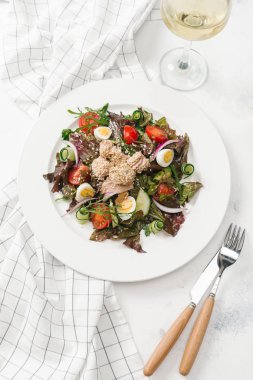 Yeşil Salata tavuk, domates, bıldırcın yumurtası ve beyaz tabakta salatalık ile