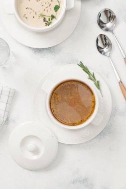 Beyaz arka plan üzerinde otlar ile iki tür krem çorba servis