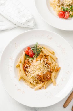 Beyaz tabak içinde sığır eti ve parmesan peynirli taze makarna üstten görünüm