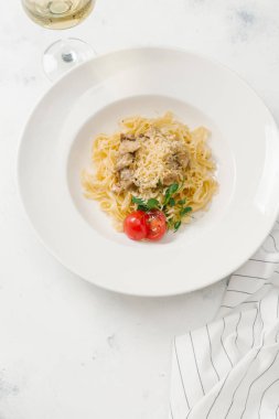 Beyaz tabakta et sos ve parmesan peynirli makarna