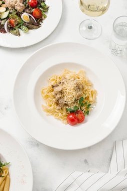 Beyaz tabakta et sos ve parmesan peynirli makarna