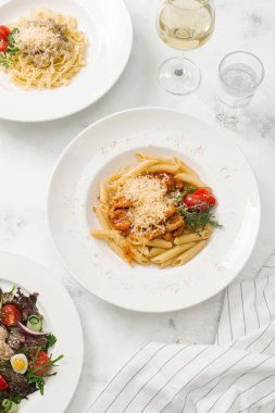 Beyaz tabak içinde sığır eti ve parmesan peynirli taze makarna üstten görünüm