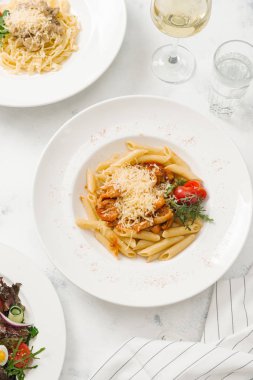 Beyaz tabak içinde sığır eti ve parmesan peynirli taze makarna üstten görünüm