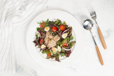 Yeşil Salata tavuk, domates, bıldırcın yumurtası ve beyaz tabakta salatalık ile