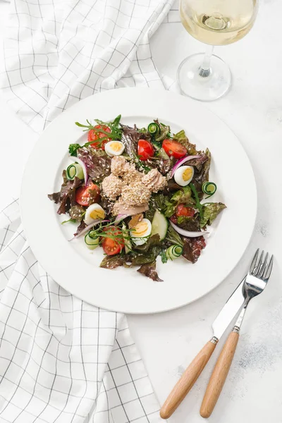 Yeşil Salata tavuk, domates, bıldırcın yumurtası ve beyaz tabakta salatalık ile