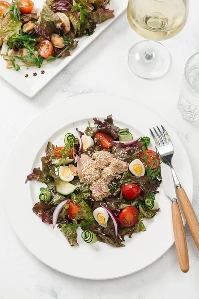 Yeşil Salata tavuk, domates, bıldırcın yumurtası ve beyaz tabakta salatalık ile