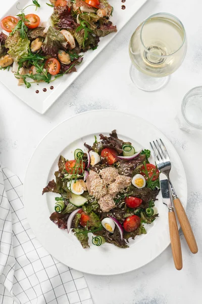 Yeşil Salata tavuk, domates, bıldırcın yumurtası ve beyaz tabakta salatalık ile