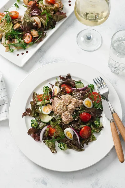 Yeşil Salata tavuk, domates, bıldırcın yumurtası ve beyaz tabakta salatalık ile