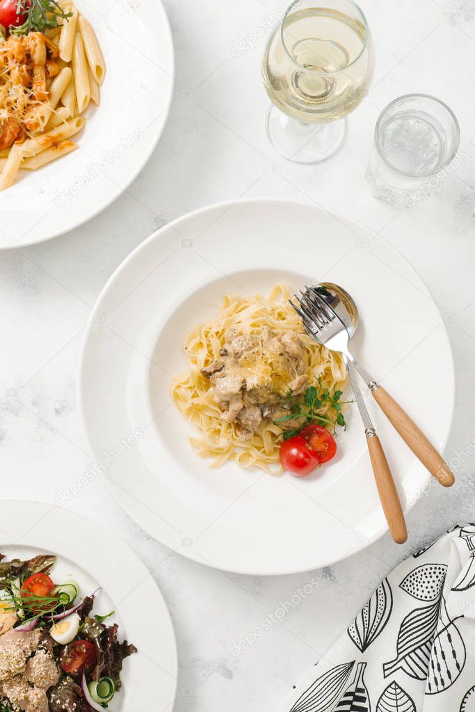 Pasta with meat gravy and parmesan cheese in white plate