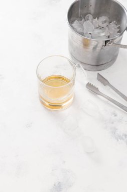 Viski beyaz beton zemin üzerine buz küpleri ile cam 