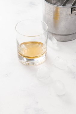Viski beyaz beton zemin üzerine buz küpleri ile cam 