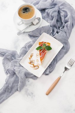 Nane yaprakları ile beyaz tabakta taze peynirli kek kahve ile görev yaptı.