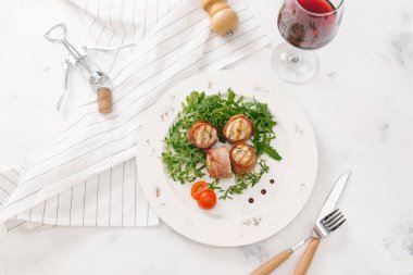 Beyaz tabakta roka salatası ile servis taze pastırma ruloları