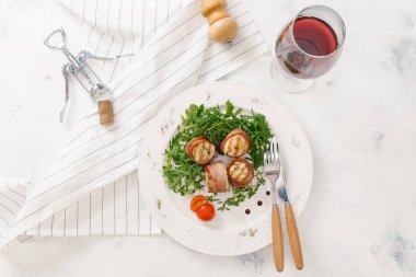 Beyaz tabakta roka salatası ile servis taze pastırma ruloları