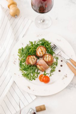 Beyaz tabakta roka salatası ile servis taze pastırma ruloları