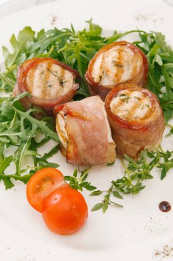 Beyaz tabakta roka salatası ile servis taze pastırma ruloları