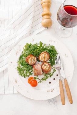 Beyaz tabakta roka salatası ile servis taze pastırma ruloları