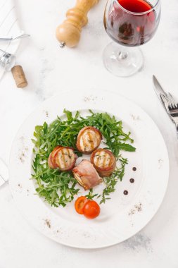 Beyaz tabakta roka salatası ile servis taze pastırma ruloları