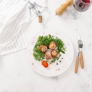 Beyaz tabakta roka salatası ile servis taze pastırma ruloları