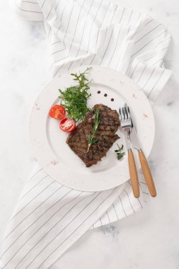 Roka ve biberiye dal beyaz tabakta servis biftek üstten görünüm