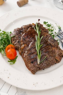 Roka ve biberiye dal beyaz tabakta servis biftek üstten görünüm