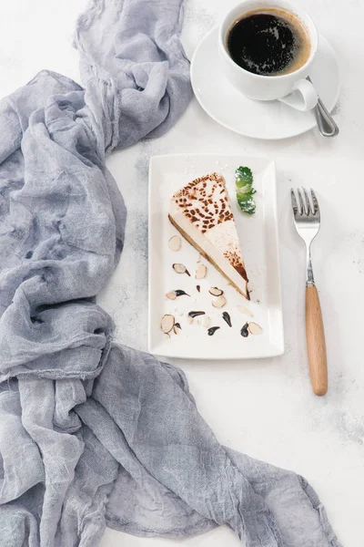 Fincan kahve ile parçası cheesecake beyaz tabakta servis