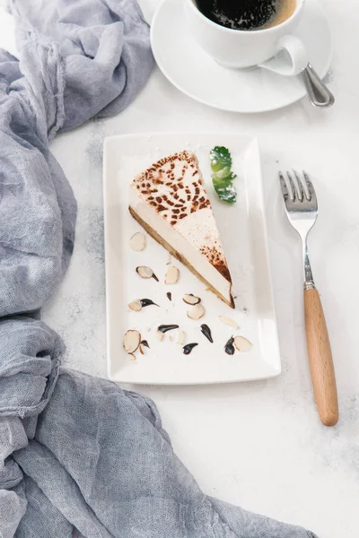Fincan kahve ile parçası cheesecake beyaz tabakta servis