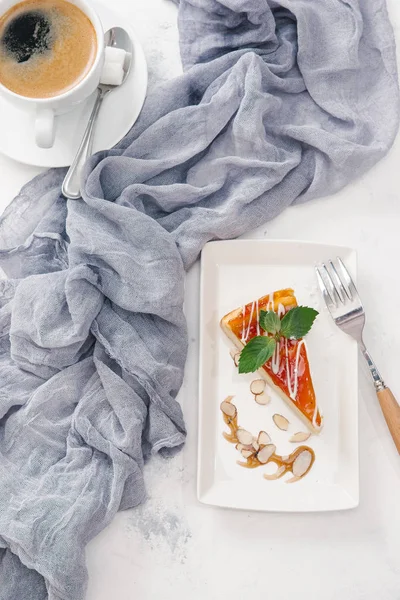 Nane yaprakları ile beyaz tabakta taze peynirli kek kahve ile görev yaptı.