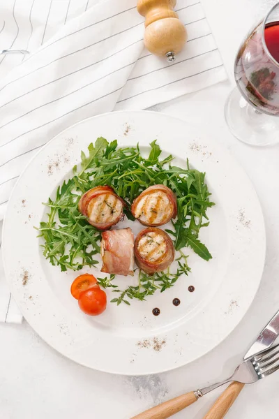 Beyaz tabakta roka salatası ile servis taze pastırma ruloları