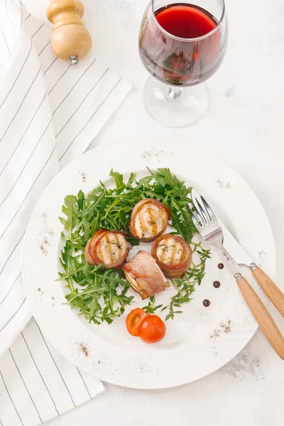 Beyaz tabakta roka salatası ile servis taze pastırma ruloları