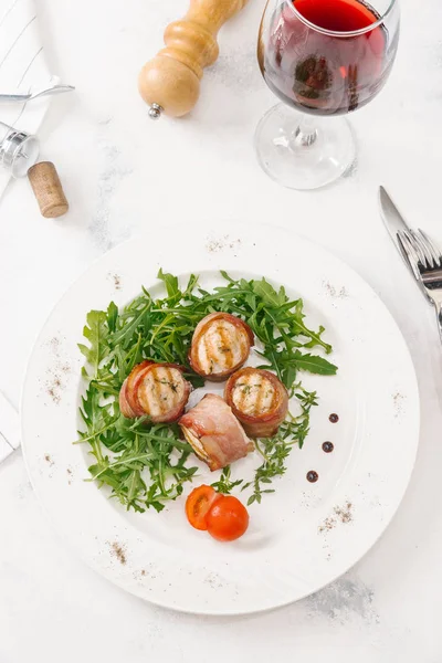 Beyaz tabakta roka salatası ile servis taze pastırma ruloları